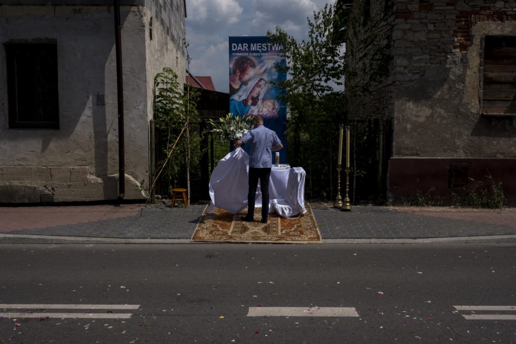 30 maja. Ulica Obrońców Poczty Gdańskiej. Jeden z mieszkańców sprząta jeden z ołtarzy po procesji Bożego Ciała.